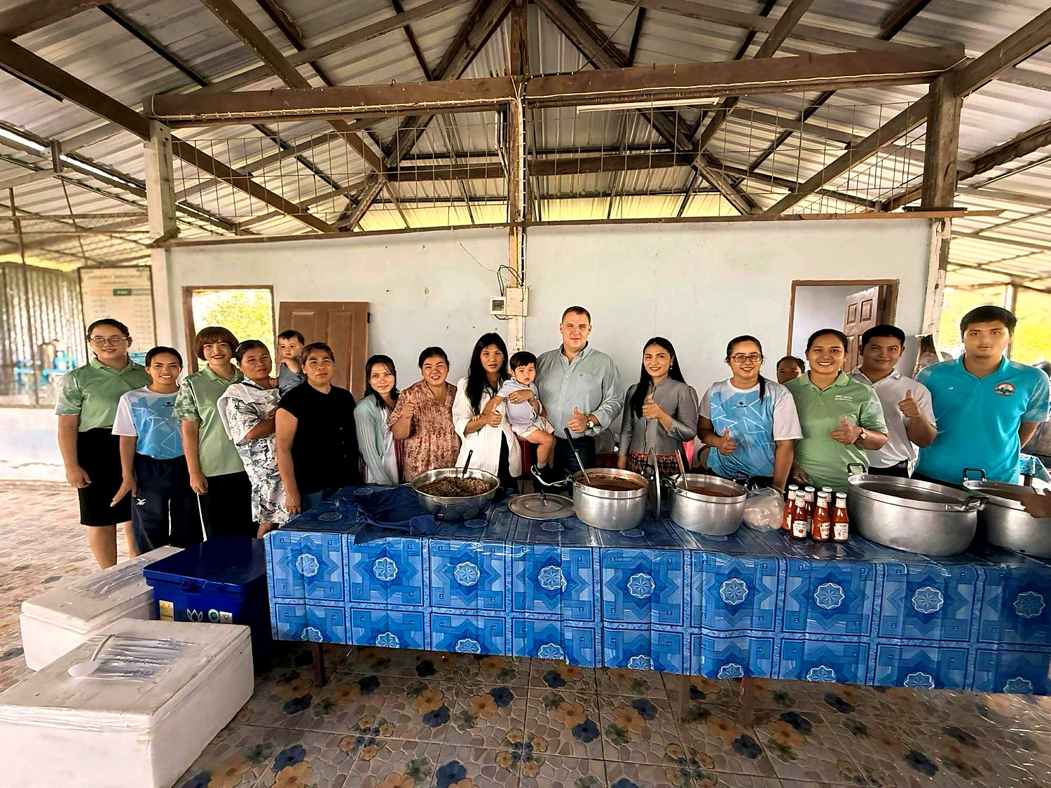 Ben and Ploy with teachers and volunteers at a village school kitchen