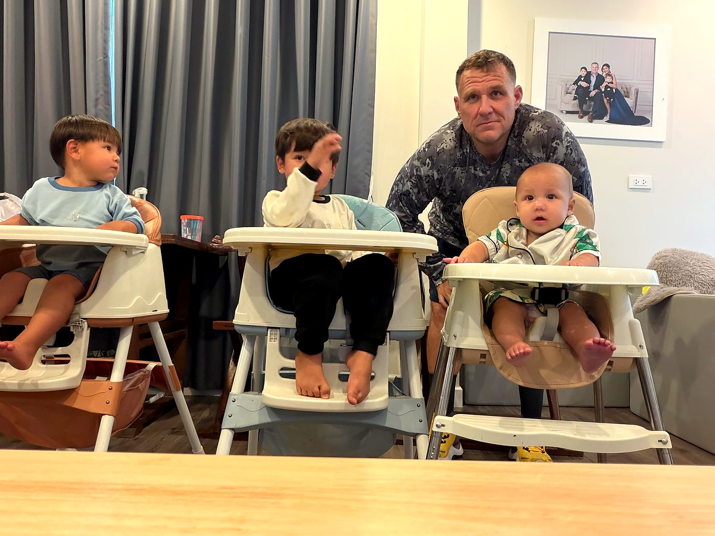 Ben with his three sons in high chairs at home