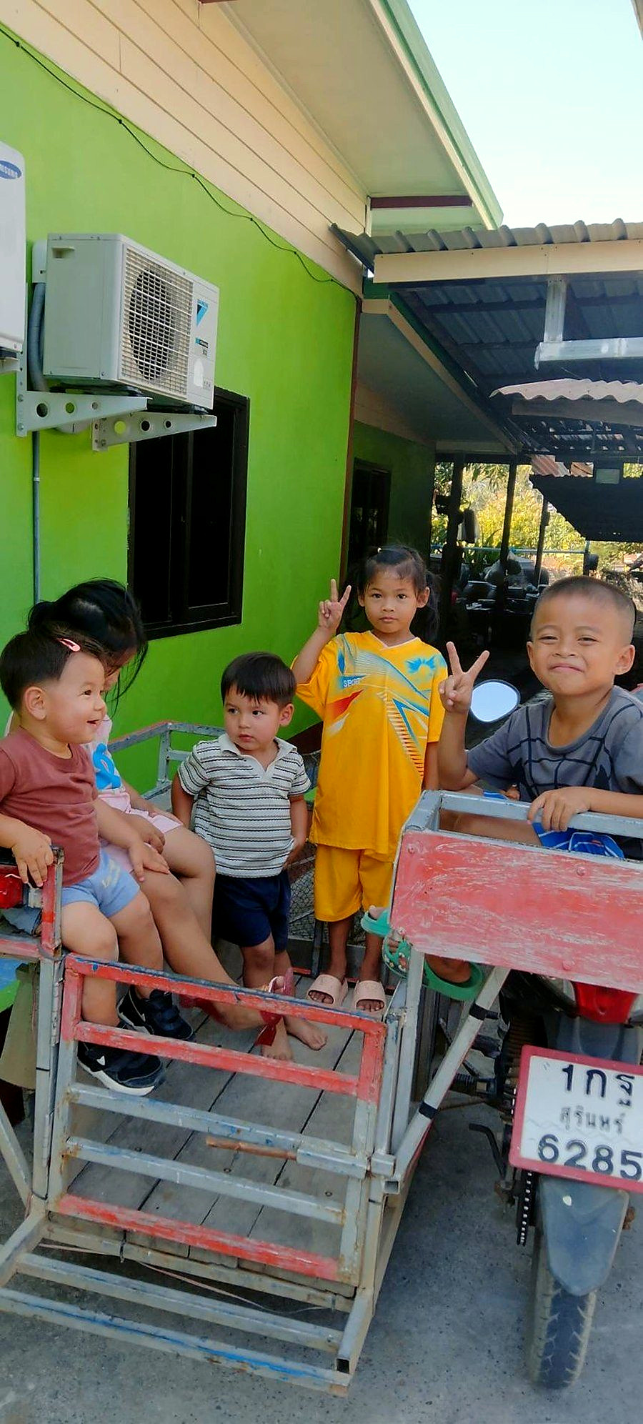Children on a motorbike cart in a Surin village